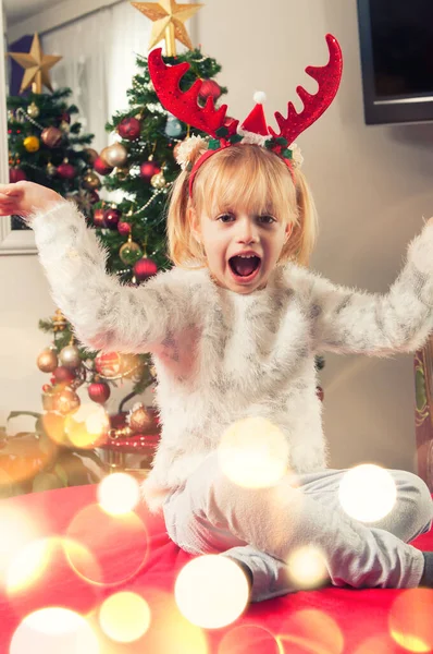 Schönes Kleines Mädchen Mit Hörnern Das Neben Dem Weihnachtsbaum Sitzt — Stockfoto