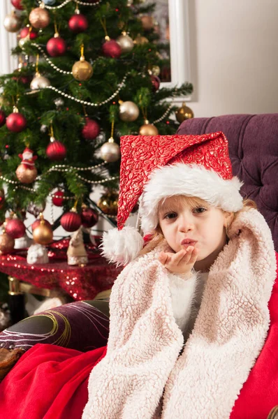 Schönes Kleines Mädchen Mit Weihnachtsmann Mütze Rote Decke Gewickelt Sitzt — Stockfoto