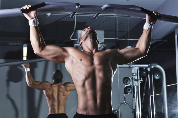 Beau modèle masculin musculaire avec corps parfait faisant tirer des hauts — Photo