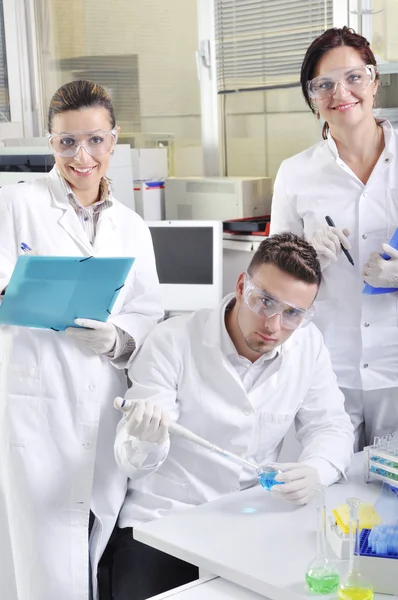 Atractivos jóvenes estudiantes de doctorado científicos observando en el labora —  Fotos de Stock