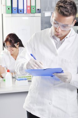 Çekici genç doktora öğrenci bilim laborat içinde bir not yazma