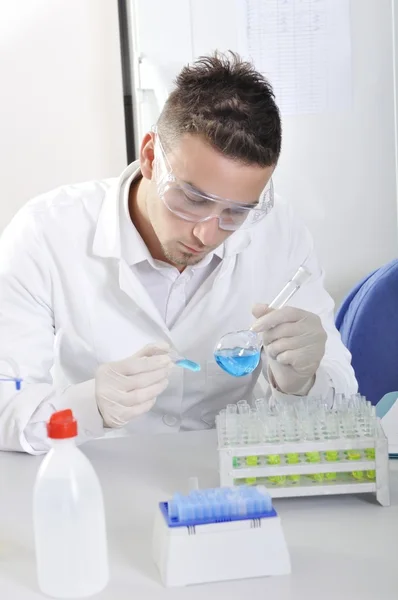 Atraente jovem cientista estudante de doutorado observando o indica azul — Fotografia de Stock