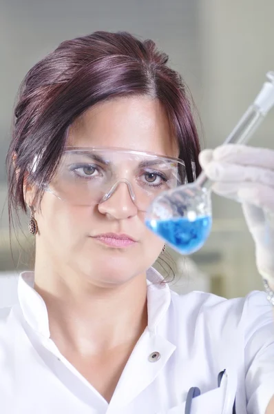 Attractive young PhD student scientist observing the blue indica — Stock Photo, Image