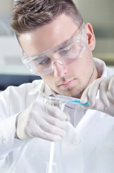 Atraente jovem cientista estudante de doutorado observando o indica azul — Fotografia de Stock