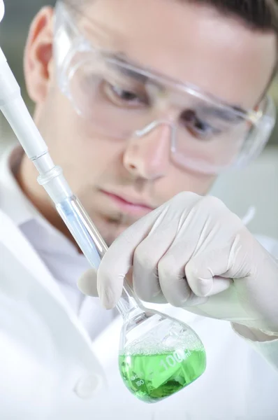 Attractive young PhD student scientist observing the green indic — Stock Photo, Image
