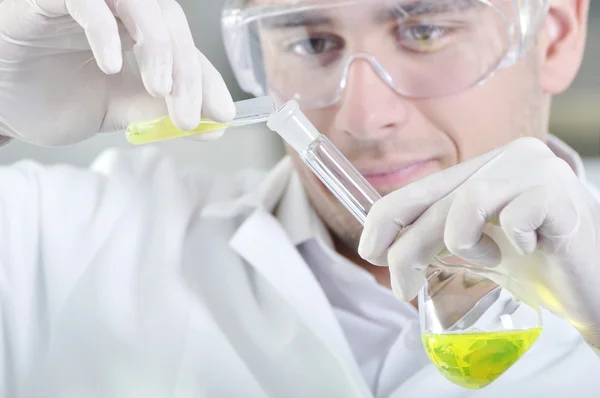 Attractive young PhD student scientist observing the yellow indi — Stock Photo, Image