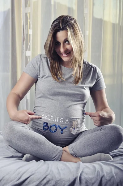 Happy framtida mamma leende och visar tecken på hennes gravid mage — Stockfoto