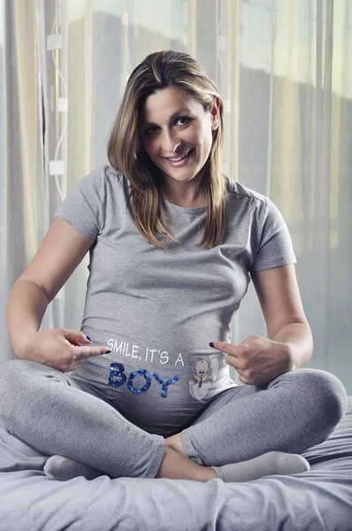 Happy framtida mamma leende och visar tecken på hennes gravid mage — Stockfoto