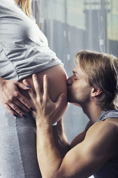 Joyeux futur papa embrassant son bébé garçon à naître — Photo