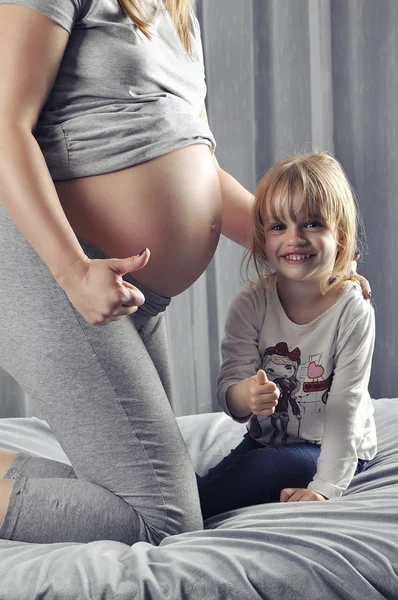 Glückliche Mutter und Tochter zeigen Daumen hoch wegen Schwangerschaft — Stockfoto
