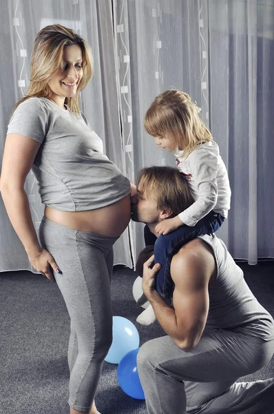 Joyeux futur papa avec sa fille sur ses épaules embrassant ventre enceinte — Photo