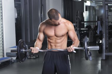 Pazı egzersiz yaparak kusursuz bir beden ile ayakta pozisyonda yakışıklı kaslı erkek modeli