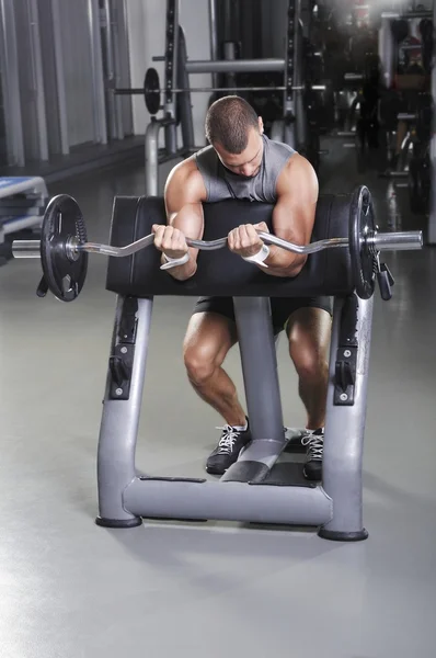 Modelo masculino muscular bonito com corpo perfeito fazendo exercício de bíceps — Fotografia de Stock