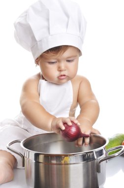 Funny adorable baby boy chef sitting and playing with kitchen equipment