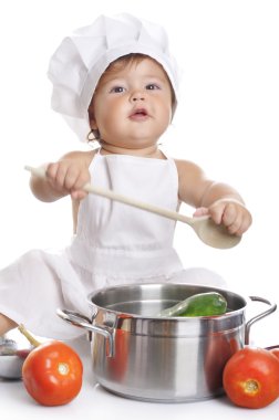 Funny adorable baby boy chef sitting and playing with kitchen equipment