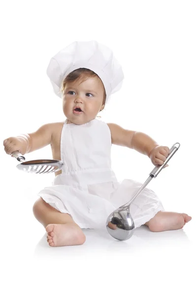 Engraçado adorável bebê menino chef sentado e brincando com equipamentos de cozinha — Fotografia de Stock