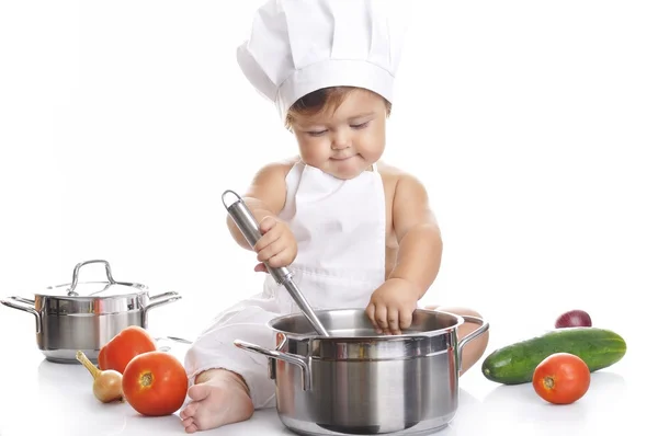 Divertido adorable bebé chef sentado y jugando con el equipo de cocina — Foto de Stock