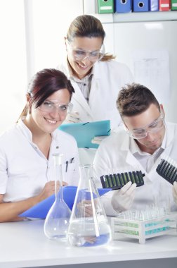 Sonra çözüm destillation kimyasal laboratuvar mavi, sarı ve yeşil gösterge renk kayması gözlemleyerek çekici genç doktora öğrencileri bilim adamları