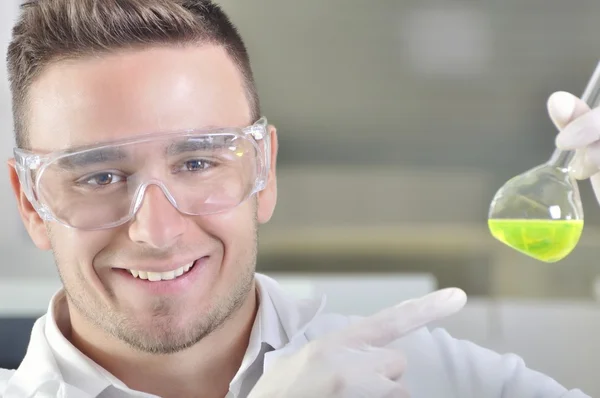Ελκυστική νεαρός επιστήμονας Phd με τον φοιτητή παρατηρώντας την αλλαγή χρώματος πράσινο δείκτη μετά το destillation λύση στο χημικό εργαστήριο — Φωτογραφία Αρχείου