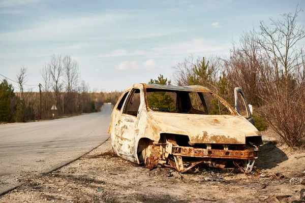 Verbrand om de grond auto wrak aan de kant van de weg Stockafbeelding