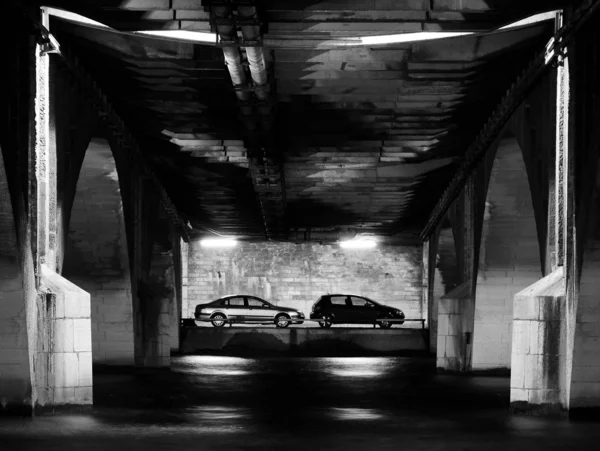 Two cars parked under the bridge. — Stock Photo, Image