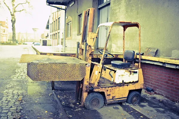 Vintage old broken forklift standing on flat tires — Stock Photo, Image