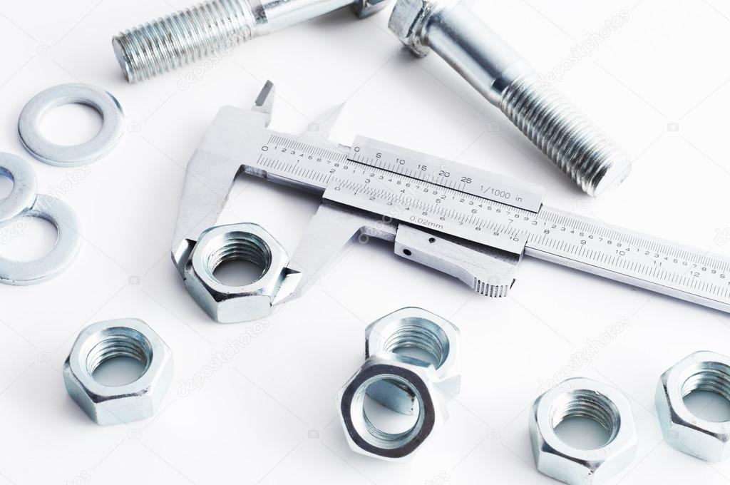 Measurement of details in the bolts and nuts industry. Measuring a diameter of a bolt with vernier caliper