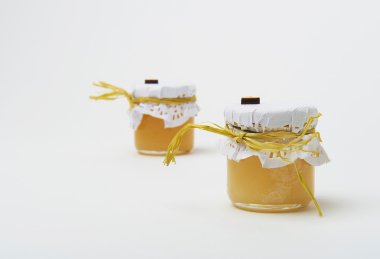 Beyaz arka plan üzerinde küçük kavanoza altın bal