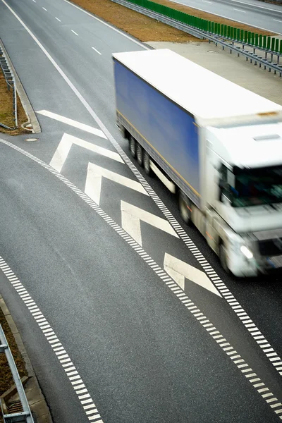 एक राजमार्ग पर ड्राइविंग धुंधला ट्रक का शीर्ष दृश्य। परिवहन में गति की प्रस्तुति . — स्टॉक फ़ोटो, इमेज