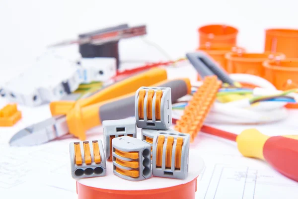 Modern connectors standing on junction box. Different electrical tools lying in background out of focus. Concept of electrical commercial. — Stockfoto