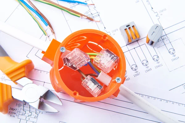 Metal cut pliers, over current electronic fuse, connected cable in electrical junction box, lying on electrical diagrams. Work tools for engineer jobs, concept of electrical works. — Stockfoto