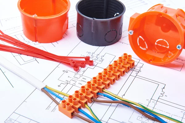 Electrical connectors with wires, junction box and different materials used for jobs in electricity. Many tools lying on diagrams. — Stockfoto