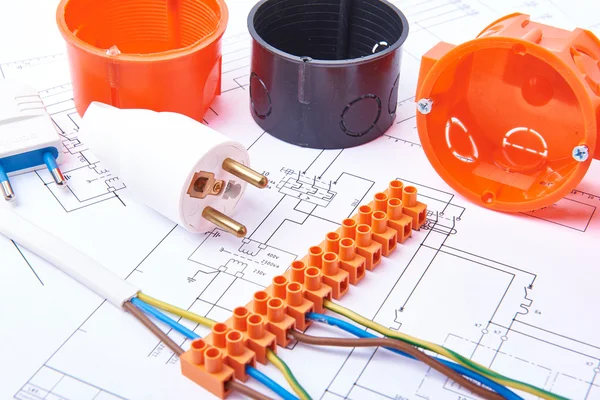 Electrical connectors with wires, junction box and different materials used for jobs in electricity. Many tools lying on diagrams. — Stockfoto