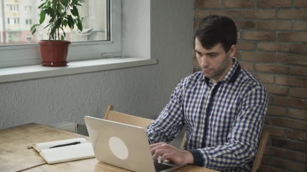 Beau homme travaillant sur l'ordinateur, sur le cahier de table et le stylo . — Video