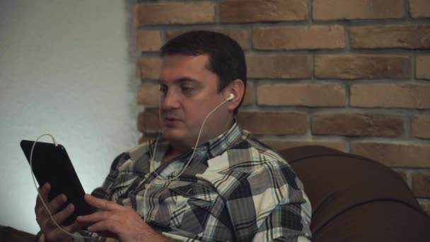 Uomo in auricolare che parla attraverso tablet . — Video Stock