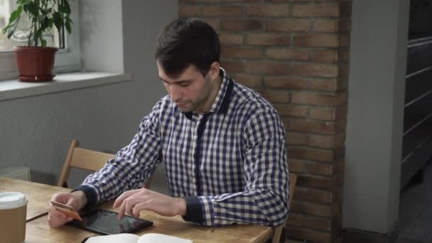 Man met Tablet PC- en creditcard zittend in een café en een beloning voor de aankoop. — Stockvideo