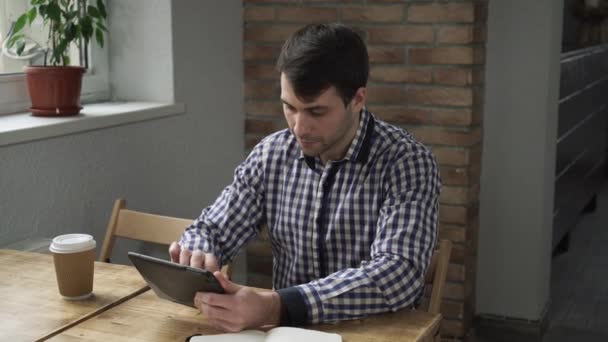 Чоловік вранці п'є каву і працює на планшеті . — стокове відео