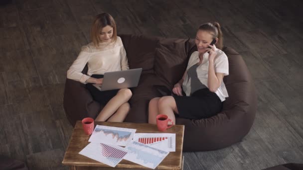 Dos mujeres de negocios en la reunión. Uso de dispositivos digitales — Vídeos de Stock