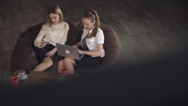 Dos mujeres comprando en línea con el ordenador portátil — Vídeo de stock