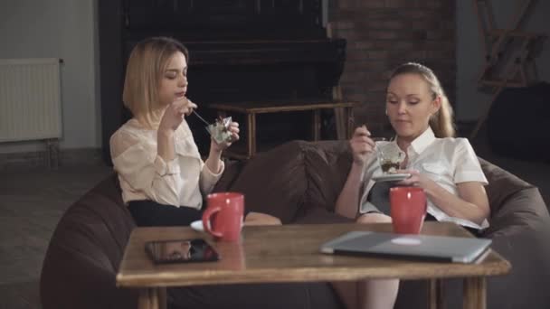 Две деловые женщины едят десерт и говорят — стоковое видео
