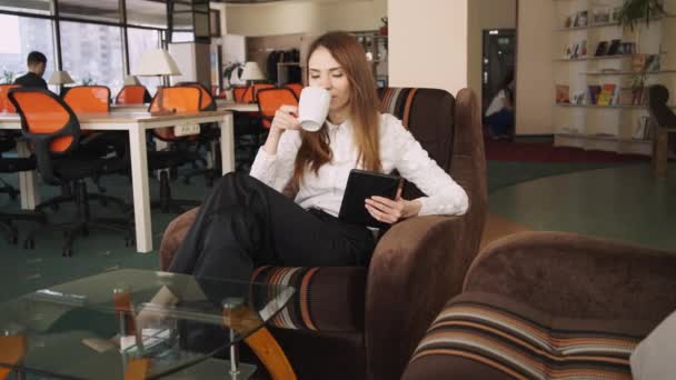 La donna trascorre il tempo libero in un Co-working. Lei leggendo notizie divertenti al social network . — Video Stock