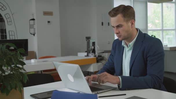 Uomo d'affari che lavora con il computer portatile in ufficio assistente donna portare per lui una tazza di caffè . — Video Stock