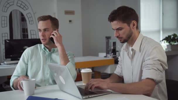 Два молодых бизнесмена, работающих в современном офисе . — стоковое видео