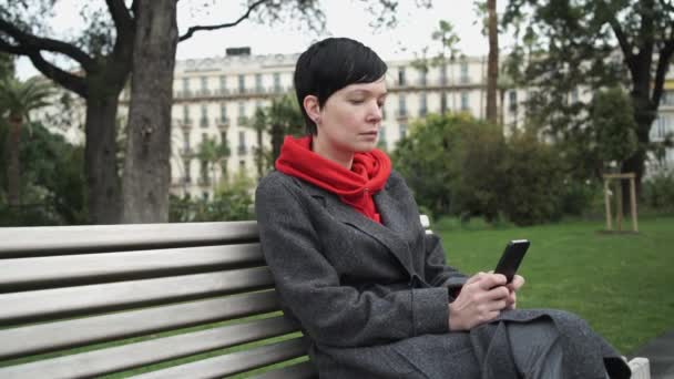 Mujer adulta utilizando la aplicación en el teléfono inteligente para enviar un mensaje . — Vídeos de Stock