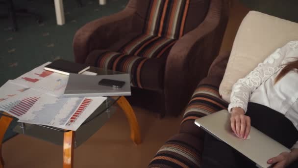 Kızıl saçlı iş kadını kanepede dizüstü bilgisayar ile yalan. — Stok video