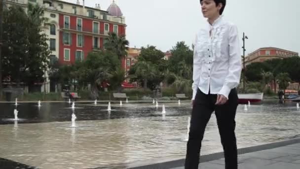 Tourist young woman walking along fountain in Nice. — Stock Video