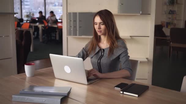 Aantrekkelijke zakenvrouw werkt met de computer op de werkplek op kantoor. — Stockvideo