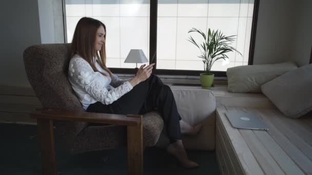 Mujer adulta en casa usando tableta de pantalla táctil y sonriendo . — Vídeo de stock