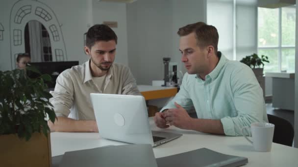 Dos jóvenes empresarios felices trabajando juntos en la oficina . — Vídeos de Stock