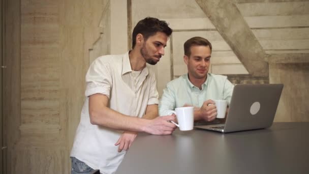 Junges Business-Team schaut auf den Computer und spricht. — Stockvideo